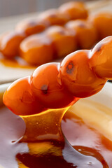 A close-up of traditional Japanese mitarashi dango—skewered rice dumplings grilled to perfection and coated with a glossy, sweet soy sauce glaze. The caramelized surface and rich glaze highlight the a