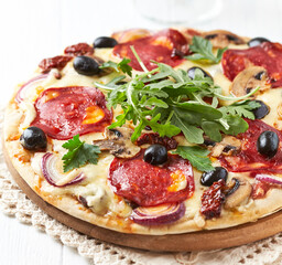 Pizza with chorizo ​​sausage, mozzarella and olives. Wooden background. Close up.