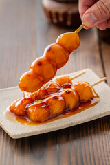 A close-up of traditional Japanese mitarashi dango&mdash;skewered rice dumplings grilled to perfection and coated with a glossy, sweet soy sauce glaze. The caramelized surface and rich glaze highlight the a