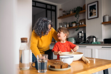 Grandmother and grandson baking together in kitchen