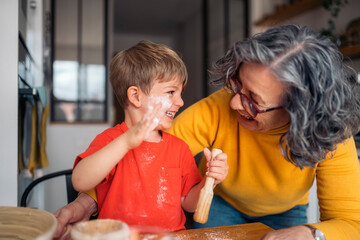 Grandmother and grandson baking together, sharing joyful moments