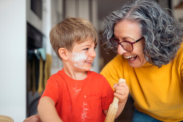 Grandmother and grandson baking and having fun in the kitchen