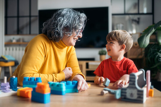 Grandmother and grandson playing with building blocks at home
