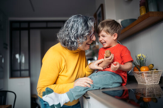 Grandmother and grandson sharing a laugh in the kitchen