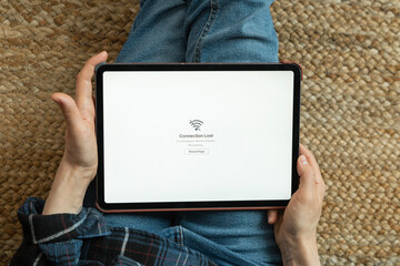 Woman holding tablet showing internet connection lost message