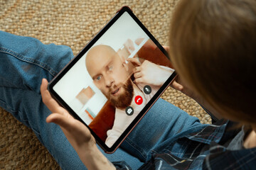 Woman frustrated by lagging video call on tablet