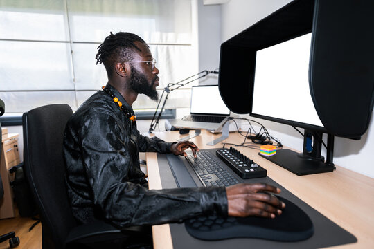 Video editor working from home office using professional monitor