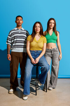 Trendy urban fashion showcased by three models in studio setting