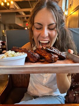 UGC of young woman eating Barbecue ribs