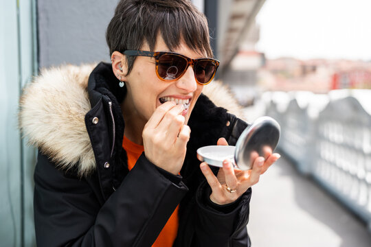 Woman putting invisible braces aligner in her mouth