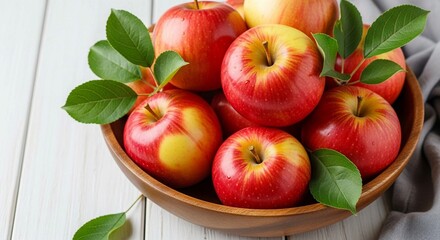 Healthy, ripe apples featuring vivid red and yellow hues, artfully arranged in a wooden fruit bowl.
