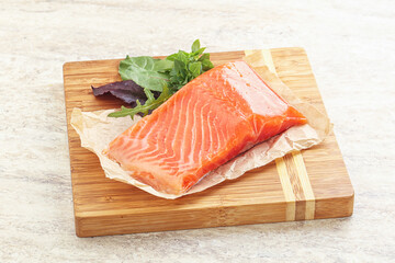 Raw salmon fillet over board