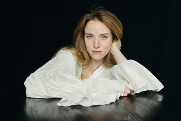 A Woman Rests Her Head on Her Hand, Radiating Calmness and Elegance