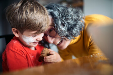 Grandmother and grandson sharing a sweet treat in the kitchen