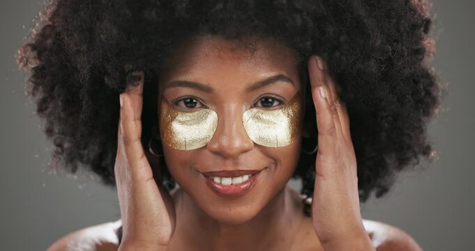 Face, skincare or black woman with glow, eye patch or cosmetics for beauty, application or shine. Depuff, studio or afro girl on grey background with pads, anti aging dermatology product or hydration