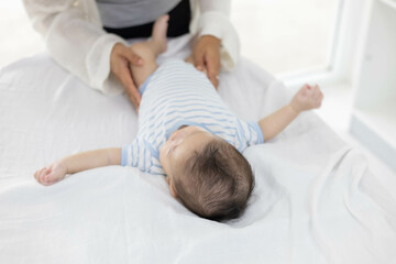 Fototapeta premium A woman is taking care of a baby. She is playing with the baby and holding it with tenderness. 