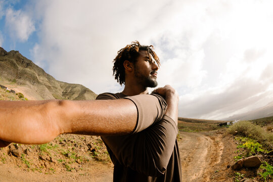 Wide shot of a professional trail runner stretching
