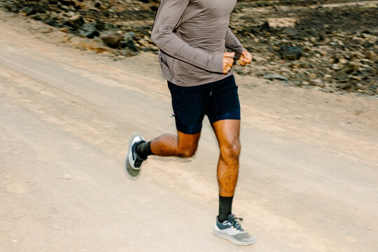 Unknown trail runner in action while training on a volcanic mountain
