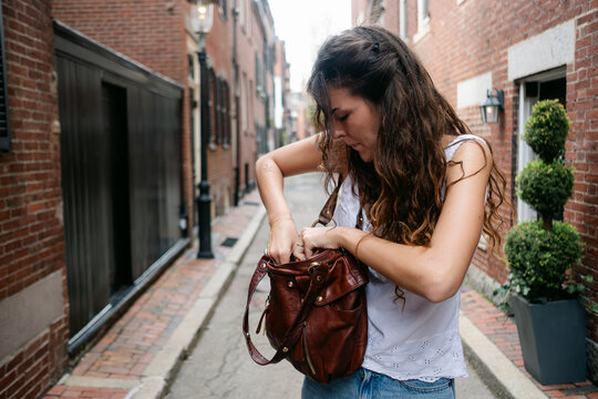 Young woman looking fro something in her bag., Boston 