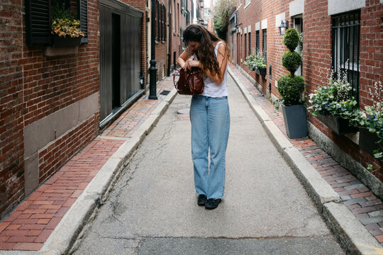 Young woman looking fro something in her bag., Boston 