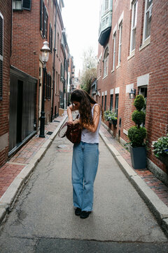 Young woman looking fro something in her bag., Boston 