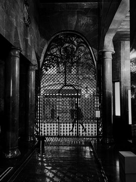 Pedestrian walking down the street, through a gate