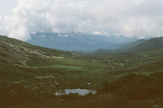 Breathtaking mountain landscape with lush valleys and dramatic clouds 