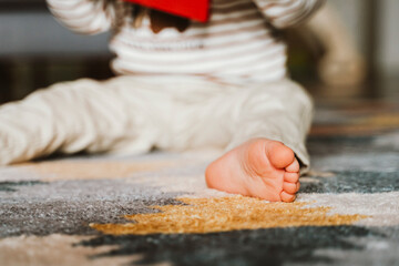 Close-Up of Child Reading and Sitting on Carpet