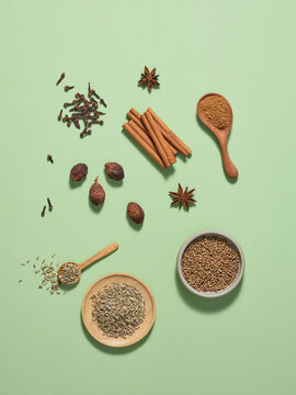 Assorted Whole and Ground Spices on a Green Background