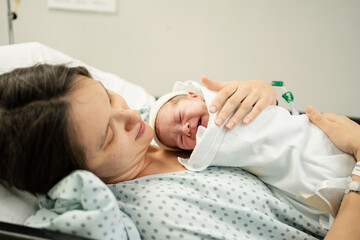 Newborn baby resting peacefully in mother's arms