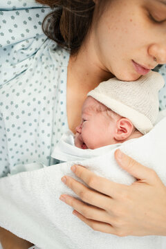 Newborn cradled by mother in hospital setting