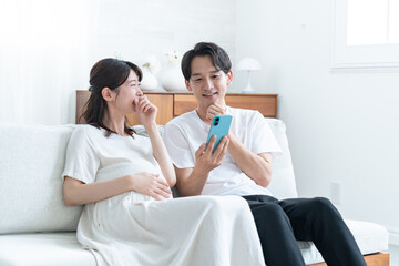 携帯を見る夫婦