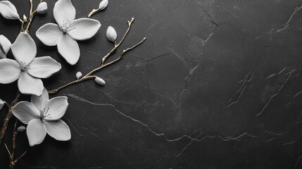 Elegant white flowers arranged on a dark stone surface.
