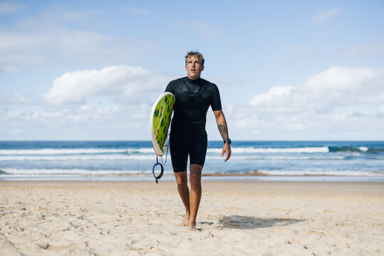 Surfer walking on the ocean after a surfing session