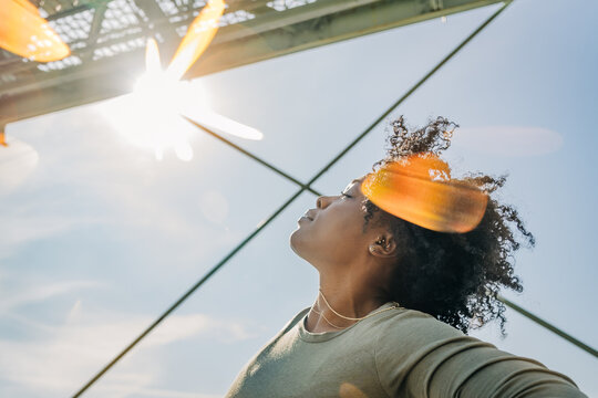 Woman basking in sunlight with head tilted back in joy