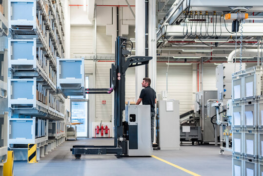 Warehouse employee operating a forklift truck indoors