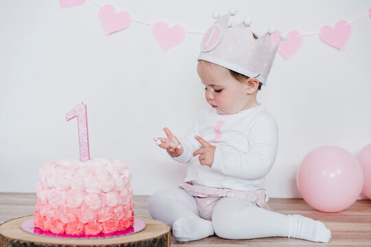 Curious girl with birthday cake at home
