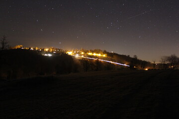 Fototapeta premium Mountain village lighting in the night with the stars in the sky