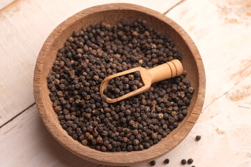 black pepper in a wooden bowl. Pepper, which has the Latin name Piper nigrum, is a plant that is...