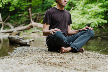 Man meditating in a serene forest setting promoting holistic health and mental well-being