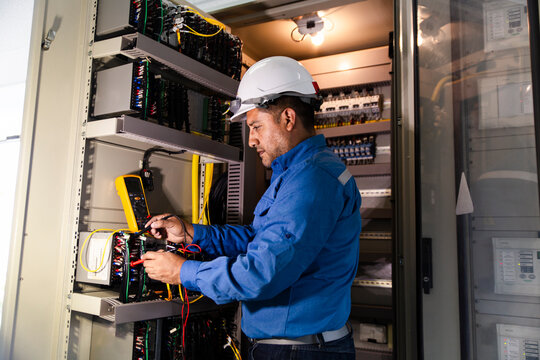 Engineer measuring voltage in a substation with a voltmeter