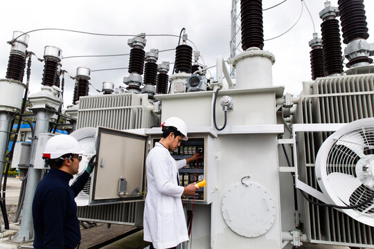 Engineers performing a voltage check on a transformer at a wind farm