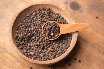 black pepper in a wooden bowl. Pepper, which has the Latin name Piper nigrum, is a plant that is rich in chemical content, such as pepper oil, fatty oil, and starch.