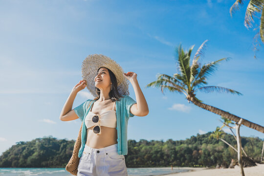 Happy traveler asian woman with hat relax on Klong chao beach at day in Koh Kood Trat Thailand Summer travel holiday vacation concept