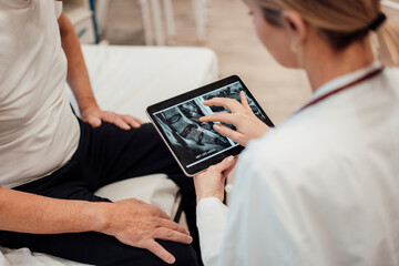 Doctor consulting with patient using tablet in medical office