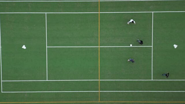Children playing five-a-side football and having fun playing an after-school football match - fun and sports during childhood - drone footage of a football sports centre
