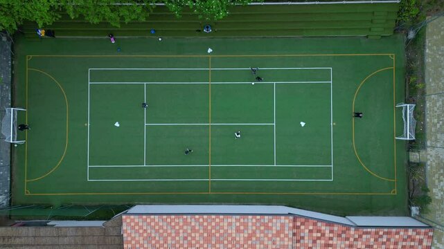 Children playing five-a-side football and having fun playing an after-school football match - fun and sports during childhood - drone footage of a football sports centre