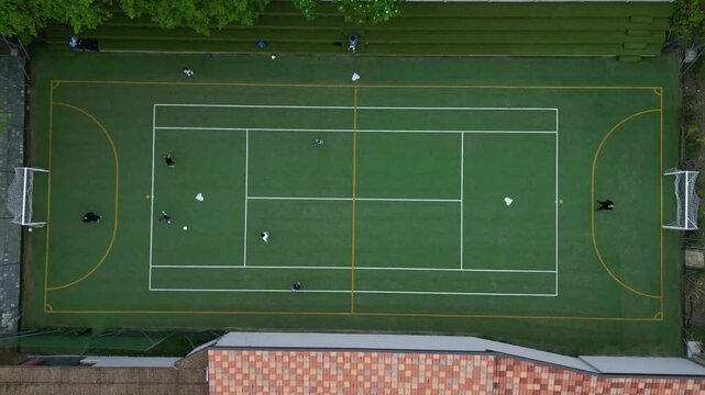 Children playing five-a-side football and having fun playing an after-school football match - fun and sports during childhood - drone footage of a football sports centre
