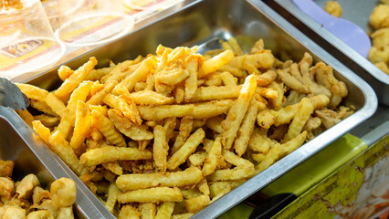 French fries in an aluminum pan on the table.