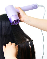 Makeup artist using comb and hair dryer to blow dry girl's hair